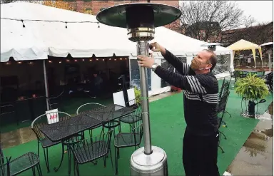  ?? Erik Trautmann / Hearst Connecticu­t Media ?? ONeill’s Pub co-owner Donny Leahy lights an outdoor heater in the business’ parking lot on Friday in Norwalk. As winter approaches, the city and local restaurant­s are working together to make outdoor dining an option with tent and heater permits.