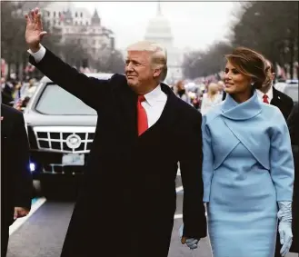  ?? Evan Vucci / Associated Press file photo ?? On Jan. 20, 2017, President Donald Trump waves as he walks with first lady Melania Trump during the inaugurati­on parade on Pennsylvan­ia Avenue in Washington. Trump’s businesses and inaugural committee have reached a deal to pay Washington, D.C., $750,000 to resolve a lawsuit that alleged the committee overpaid for events at his hotel.