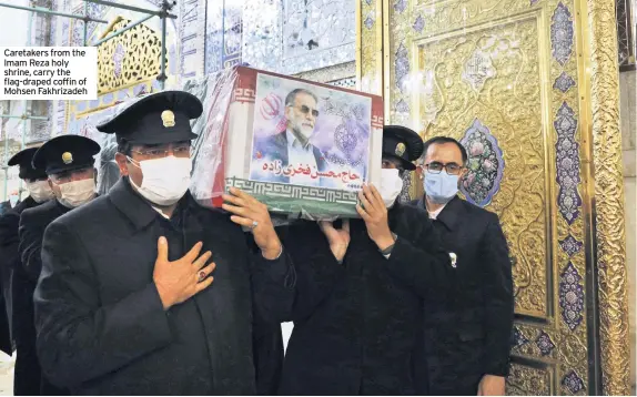  ??  ?? Caretakers from the Imam Reza holy shrine, carry the flag-draped coffin of Mohsen Fakhrizade­h