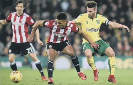  ??  ?? Brentford’s Ollie Watkins (left) keeps Norwich defender Ivo Pinto at bay in last night’s Championsh­ip clash at Carrow Road.