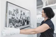  ?? FOTO: DPA ?? Stefanie Thomas, Mitarbeite­rin in der Kunsthalle Messmer, hängt ein Foto des Models Sylvette David mit Pablo Picasso auf.