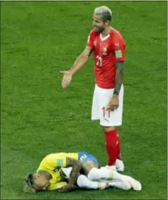  ?? ANDREW MEDICHINI — THE ASSOCIATED PRESS ?? Switzerlan­d’s Valon Behrami reacts as Brazil’s Neymar lies on the ground during their match at the World Cup in Rostov-on-Don, Russia on Sunday.