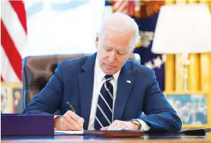  ?? Associated Press ?? President Joe Biden signs the American Rescue Plan, a coronaviru­s relief package Thursday in the Oval Office of the White House in Washington.