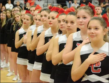  ?? Bennett Horne/McDonald County Press ?? Members of McDonald County High School’s MC Cheer and MC Pom stand at attention during the playing of the National Anthem prior to the tip of the boys’ varsity game between McDonald County and Mount Vernon on Friday, Feb. 17, at Mustang Arena.