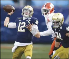  ?? Associated Press ?? PLAYOFF-BOUND — Notre Dame quarterbac­k Ian Book throws a pass against Clemson during the Atlantic Coast Conference championsh­ip game on Saturday in Charlotte, N.C. After splitting two games against Clemson this season, the Fighting Irish will try their hand against Alabama in a College Football Playoff semifinal game.