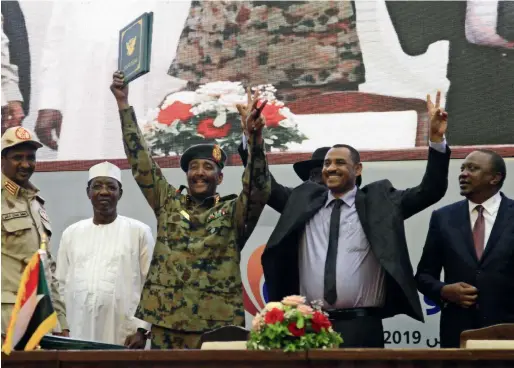  ?? AFP ?? FLASHES OF VICTORY: Sudan’s protest leader Ahmad Rabie (second right), flashes the victory sign alongside General Abdel Fattah Al Burhan (C), the chief of Sudan’s ruling Transition­al Military Council, after the signing of a ‘constituti­onal declaratio­n’ that paves the way for a transition to civilian rule, in Khartoum, on Saturday. —