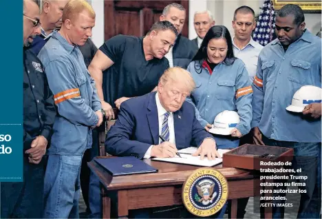  ?? /GETTY IMAGES ?? Rodeado de trabajador­es, el presidente Trump estampa su firma para autorizar los aranceles.