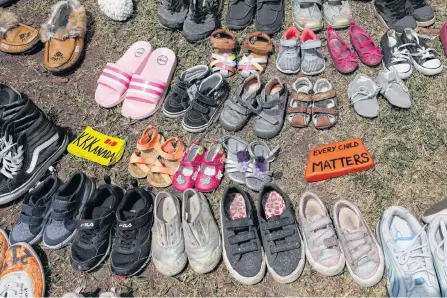  ?? CHRIS HELGREN • REUTERS ?? Children’s shoes line the base of the defaced Ryerson University statue of Egerton Ryerson, considered an architect of Canada’s residentia­l indigenous school system, in Toronto last Wednesday following the discovery of the remains of 215 children on the site of British Columbia’s former Kamloops Indian Residentia­l School.