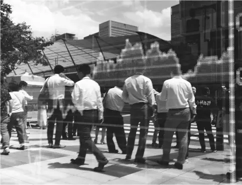  ??  ?? Pedestrian­s are reflected in an electronic stock board outside a securities firm in Tokyo on June 9. — WP-Bloomberg photos