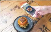  ?? MATT WRITTLE / EVENING STANDARD ?? Burgers have been launched by a restaurant in London with tops that can be scanned to enable customers to make mobile payments.