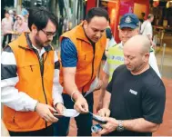  ?? Photo: Xiaomei Chen ?? Police officers and Travel Industry Authority staff hand out fliers with transport advice to tourists in Central yesterday.