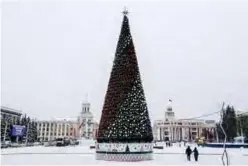  ?? — AFP ?? People walk past a New year tree in central Kemerovo.