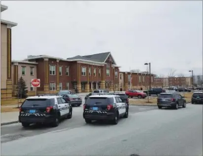  ?? Photos by Joseph B. Nadeau ?? Police vehicles surround the entrance to Woonsocket’s Hamlet Middle School on Friday after school personnel discovered a bag of bullets in a bathroom at around 1:40 p.m., near the time of student dismissal.