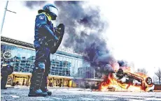  ?? — AFP photo ?? A car set on fire in front of the train station in Eindhoven, after a rally by several hundreds of people against the corona policy.