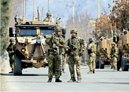  ?? — AP ?? British soldiers with NATO-led Resolute Support Mission forces arrive near the site of an attack in Kabul, Afghanista­n on Friday. An Afghan official said gunmen in Afghanista­n’s capital attacked a remembranc­e ceremony for a minority Shiite leader.
