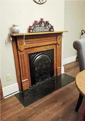  ??  ?? The dining room fireplace has a period mantel, granite hearth and original black iron insert.