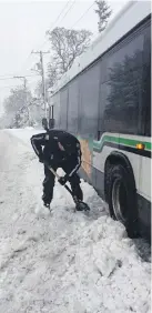  ??  ?? Digging out a B.C. Transit bus that got into difficulti­es near the Royal Oak Exchange on Tuesday.