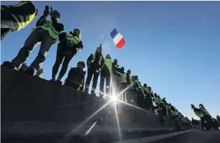  ?? PHOTO: REUTERS ?? Stop there . . . People wearing yellow vests, a symbol of a French drivers’ protest against higher fuel prices, block the motorway in Antibes.