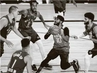  ?? Pool / Getty Images ?? Back after the birth of his son and four days of quarantine, Jazz guard Mike Conley, center, had 27 points in a Game 3 vicory over the No. 3 seed Nuggets on Friday.