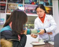  ?? PROVIDED TO CHINA DAILY ?? From left: Xie Ai’e treats a patient at a clinic in Honghu city, Hubei province.
