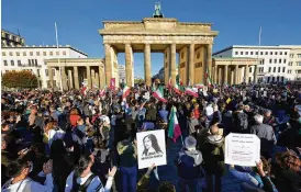  ?? MICHAEL SOHN/AP ?? People gather at the Brandenbur­g Gate in Berlin, Germany, Friday in memory of Mahsa Amini, who died after being arrested by Iran’s ‘morality police’.