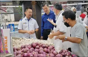  ?? ?? (From left) Peter and Wong having a chat with one of the shoppers at Boulevard Hypermarke­t Kuching.