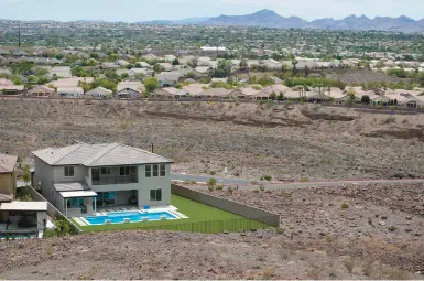  ?? JOHN LOCHER/AP ?? A home featuring a swimming pool is abutted by desert last week in Henderson, Nevada, a suburb of Las Vegas.