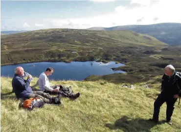  ??  ?? Taking a break Some of the members enjoy a well earned rest as they look across Loch Skeen to Lochcraig Head