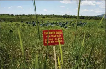  ?? MAIKA ELAN — THE ASSOCIATED PRESS FILE ?? A warning sign stands in a field contaminat­ed with dioxin near Danang airport, during a ceremony marking the start of a project to clean up dioxin left over from the Vietnam War, at a former U.S. military base in Danang, Vietnam. The sign reads; “Dioxin contaminat­ion zone - livestock, poultry and fishery operations not permitted.” Vietnam and the United States have finished cleaning up dioxin contaminat­ion at the airport caused by the transport and storage of the herbicide on and around the area.