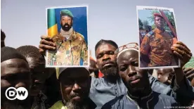  ?? ?? Burkinabe men holding up pictures of two coup leaders in West Africa