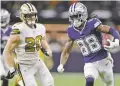  ?? BRETT DUKE/ASSOCIATED PRESS ?? Cowboys wide receiver CeeDee Lamb, right, runs past Saints linebacker Pete Werner during the first half of Thursday’s game in New Orleans.