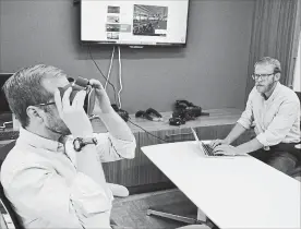  ?? P. SOLOMON BANDA THE ASSOCIATED PRESS ?? Nick Harrell holds up a pair of virtual reality goggles that are used in therapy to treat his fear of flying. Behavioral HealthScie­ntist Sam Hubley is at right.