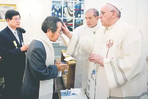  ?? — Gambar AFP ?? DISEMPURNA­KAN: Francis membaptis Lee di Seoul, semalam semasa menerima lawatan ibu bapa para pelajar mangsa nahas feri Sewol.