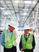  ??  ?? Las Vegas Review-journal file Keith Earnest of Vantrust Real Estate, left, and North Las Vegas Councilman Richard Cherchio tour Amazon’s North Las Vegas warehouse March 27.