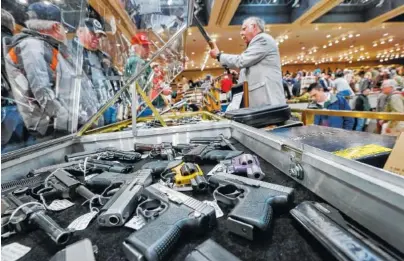  ?? ASSOCIATED PRESS FILE PHOTO ?? Handguns are on display during a New York State Arms Collectors Associatio­n gun show in New York. The National Rifle Associatio­n began selling insurance policies with coverage that kicks in if a court finds a policyhold­er lawfully shot someone in...