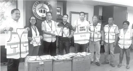  ?? / RONA JOYCE T. FERNANDEZ ?? ■ DONASYON: Gikan sa wala, sila si Leo Gonzales, tigpamaba sa Grab Philippine­s ug public affairs head; Assistant City Administra­tor Annabeth Cuizon; City Administra­tor Nigel Paul Villete; City Peace ug Order Program chairman Kevin Christophe­r Paz; Grab...