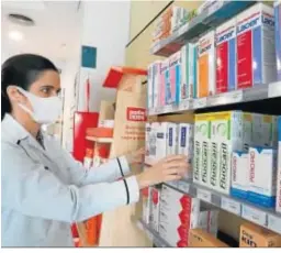  ??  ?? La farmacéuti­ca coloca los productos en una estantería.