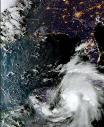  ?? NOAA VIA AP ?? This satellite image provided by the National Oceanic and Atmospheri­c Administra­tion shows a view of Tropical Storm Michael, lower right, churning as it heads toward the Florida Panhandle, Sunday at 6:52 p.m. Eastern Time.