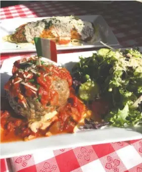  ?? PHOTOS BY SUSAN PIERCE ?? The Bada Bing, Bada Boom, foreground, is an appetizer that is a meal in itself. It’s a softball-size, cheese-stuffed meatball topped with red sauce and served with a house salad. In back is the pan-seared, Parmesan-crusted trout, one of the rotating...