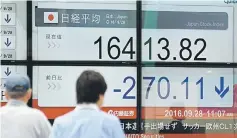  ??  ?? Pedestrian­s walk in front of an electronic­s stock display in the window of a securities company in Tokyo. Tokyo shares opened lower on September 28 as an uptick in the yen spawned worries about exports. — AFP photo