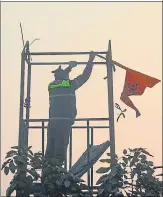  ?? SANCHIT KHANNA/HT PHOTO ?? A security person at Red Fort takes off the Nishan Sahib flag that was hoisted there on Tuesday.