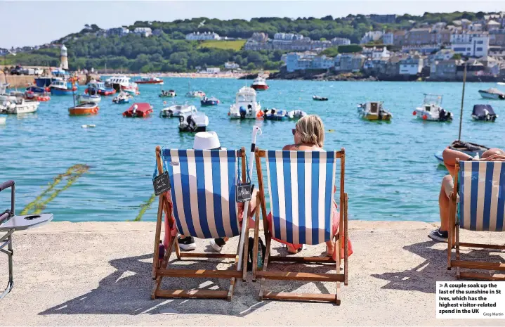  ?? Greg Martin ?? > A couple soak up the last of the sunshine in St Ives, which has the highest visitor-related spend in the UK