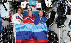  ?? Photograph: Roscosmos/Reuters ?? Russian cosmonauts Oleg Artemyev, Denis Matveev and Sergey Korsakov pose with a flag of the self-proclaimed Luhansk People's Republic at the Internatio­nal Space Station.