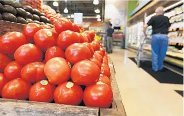  ?? CARLINE JEAN/STAFF PHOTOGRAPH­ER ?? Tomatoes from an Immokalee farm are displayed for sale at Whole Foods, which signed the penny-a-pound agreement.
