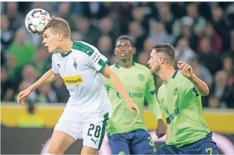  ?? FOTO: BERND THISSEN/DPA ?? Reaktionss­chneller am Arbeitspla­tz: Der Mönchengla­dbacher Nationalsp­ieler Matthias Ginter ist in dieser Szene vor den verdutzten Schalkern Breel Embolo und Mark Uth am Ball.