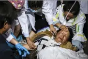  ?? HU CHAO/XINHUA VIA ASSOCIATED PRESS ?? In this photo released by China’s Xinhua News Agency, medical workers treat a woman after an earthquake in Yangbi Yi Autonomous County in southweste­rn China’s Yunnan Province, early Saturday.