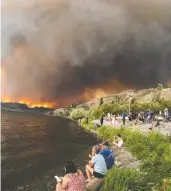  ?? DARREN HULL / AFP VIA GETTY IMAGES FILES ?? Residents watch the Mcdougall Creek wildfire in West Kelowna, B.C., from Kelowna on August 17, 2023. Last year's wildfire season broke records for its intensity.