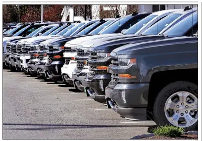  ?? AP ?? Chevrolet Silverados sit on display at a dealership in Manchester, N.H., in April. Auto sales in December ended the year on a bright note, but analysts think sales will fall a bit further this year.