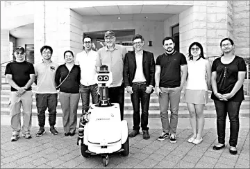  ??  ?? The project team with JackRabbot 2 (from left): Patrick Goebel, Noriaki Hirose, Tin Tin Wisniewski, Amir Sadeghian, Alan Federman, Silvio Savarese, Roberto Martín-Martín, Pin Pin Tea-mangkornpa­n and Ashwini Pokle. — Photo by Amanda Law