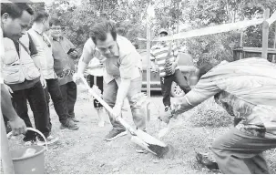  ??  ?? KOMITED: Jamawi menanam pokok sebagai simbolik perasmian program santai dan dialog bersama penduduk.